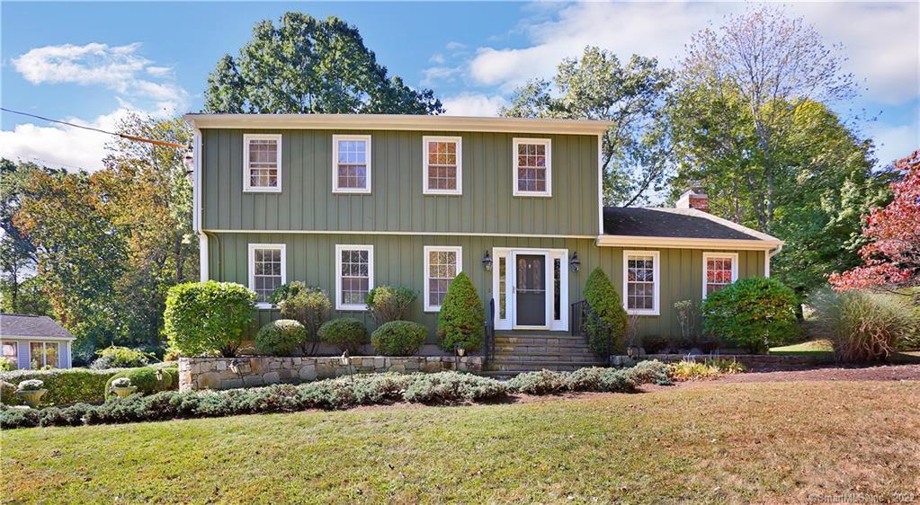 a front view of a house with a yard and potted plants