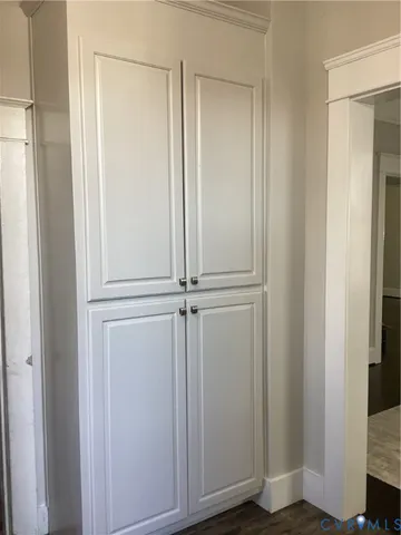 a view of a closet area with hardwood floor
