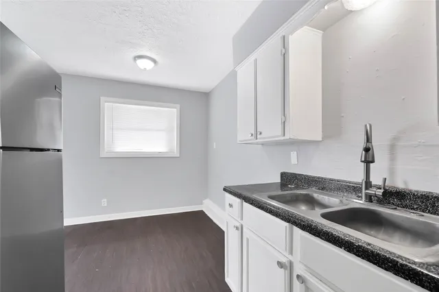 a kitchen with granite countertop a sink and a white stove next to a large window