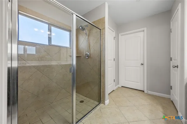 a bathroom with a shower and a glass door