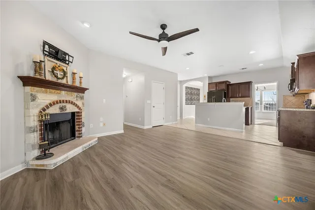a view of a livingroom with a fireplace and a ceiling fan