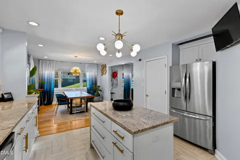 a kitchen with stainless steel appliances granite countertop a sink refrigerator and cabinets