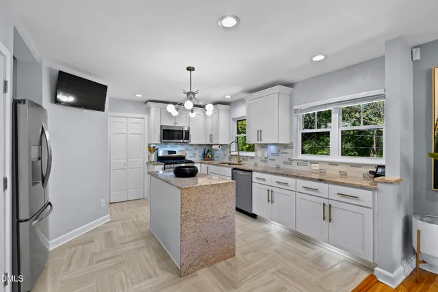 a kitchen with granite countertop a sink stove and refrigerator