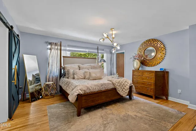 a bed room with a bed mirror and a dresser