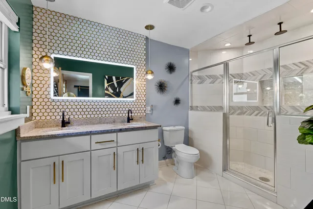 a bathroom with a toilet sink and double vanity