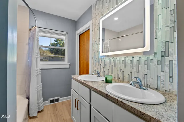 a bathroom with a granite countertop sink and a mirror