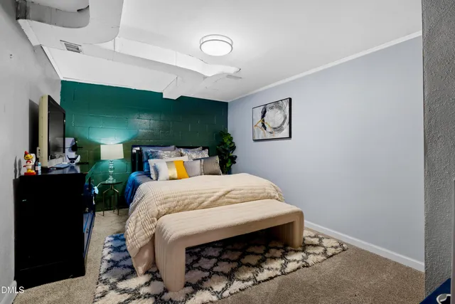 a bed sitting in a room next to a lamp