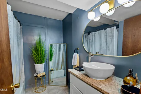 a bathroom with a granite countertop sink and a mirror