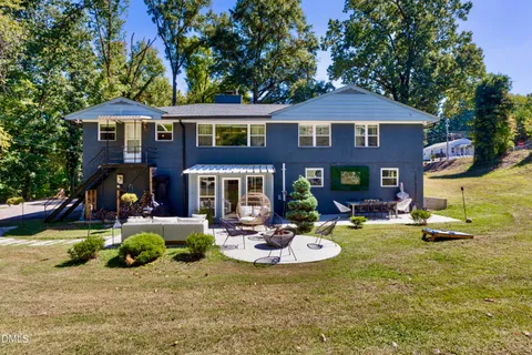 a view of a house with backyard water fountain and sitting area