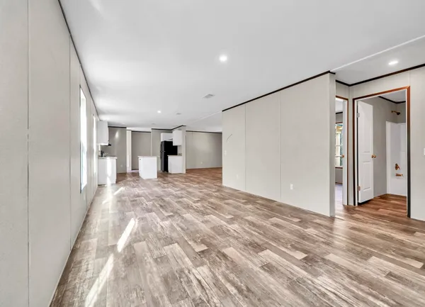 a view of a big room with wooden floor and windows