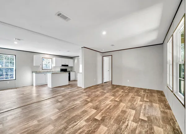 a view of empty room with wooden floor and window