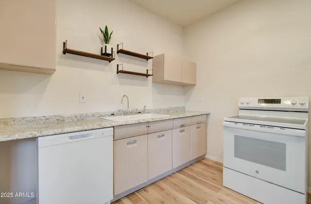 a kitchen with granite countertop white cabinets and white appliances