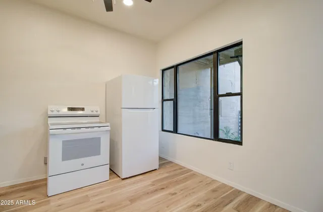 a view of empty room with wooden floor and electronic appliances