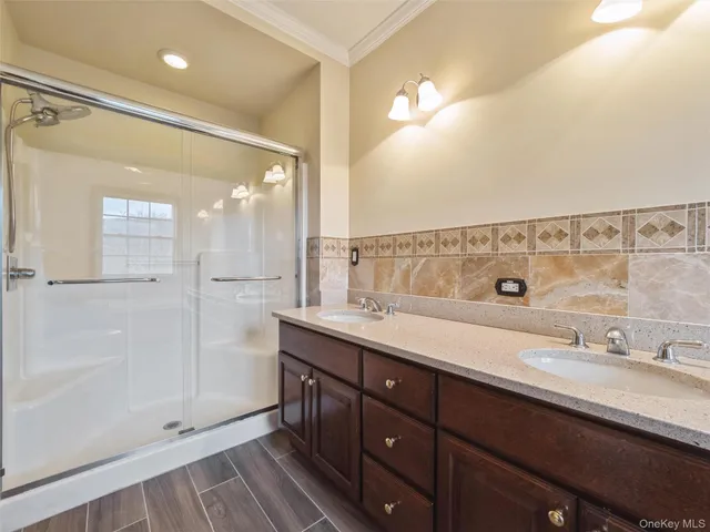 a bathroom with a double vanity sink mirror and shower