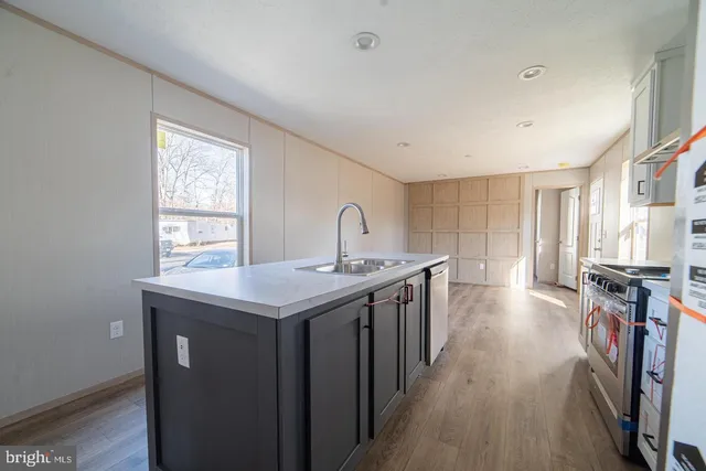 a kitchen with sink stove and refrigerator