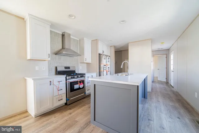 a kitchen with stainless steel appliances a stove and wooden floor