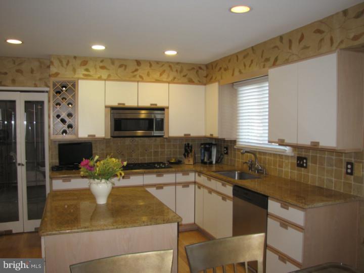 217 Sandringham Road Cherry Hill, NJ 08003 - Photo 7 of 25 a kitchen with a sink a counter top space cabinets and stainless steel appliances