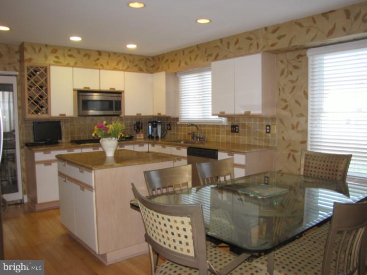 217 Sandringham Road Cherry Hill, NJ 08003 - Photo 8 of 25 a kitchen with stainless steel appliances granite countertop a stove a sink a microwave a refrigerator white cabinets and couches