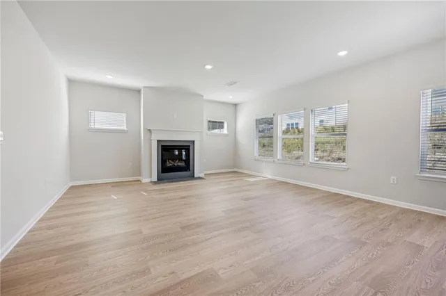 an empty room with windows and a fireplace