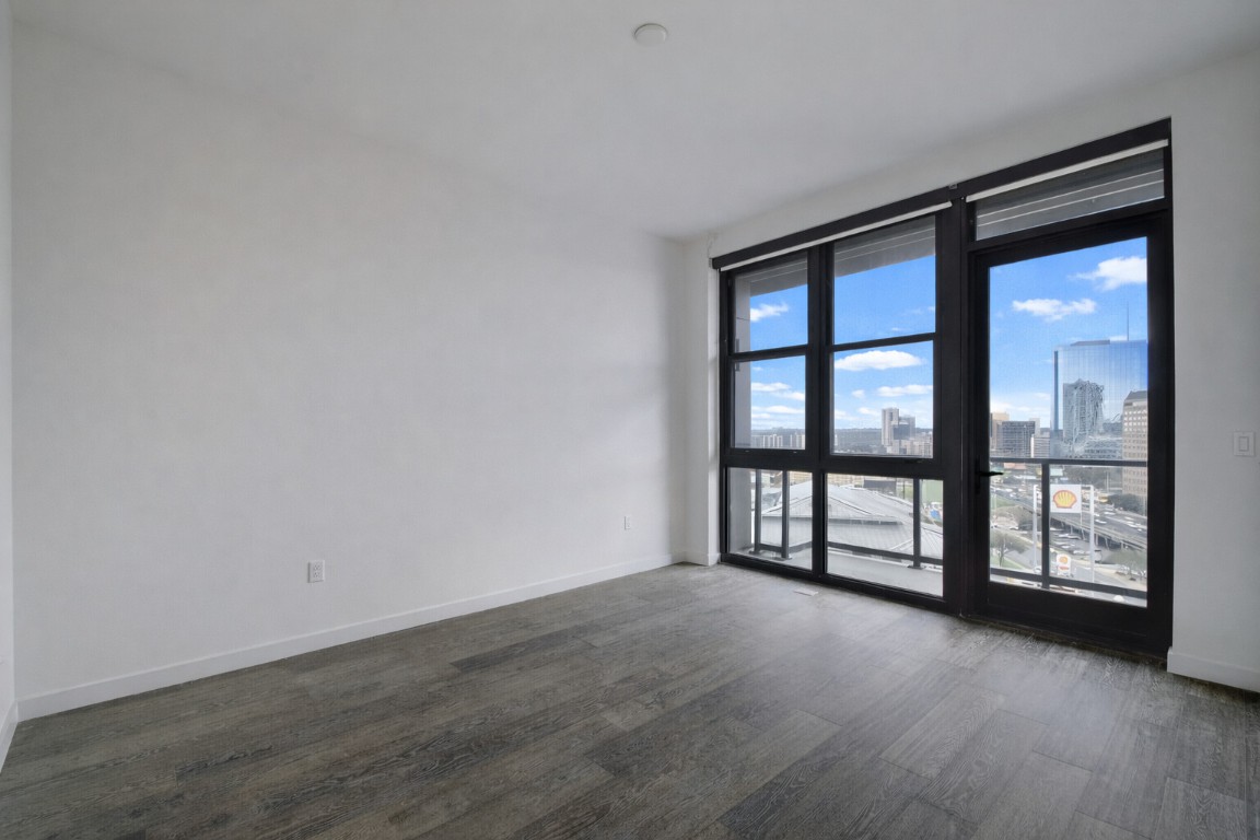 800 Embassy Drive, Unit 606 Austin, TX 78702 - Photo 15 of 38 wooden floor in an empty room with a window