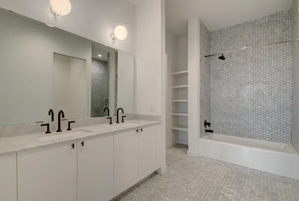 a bathroom with a double vanity sink mirror and shower