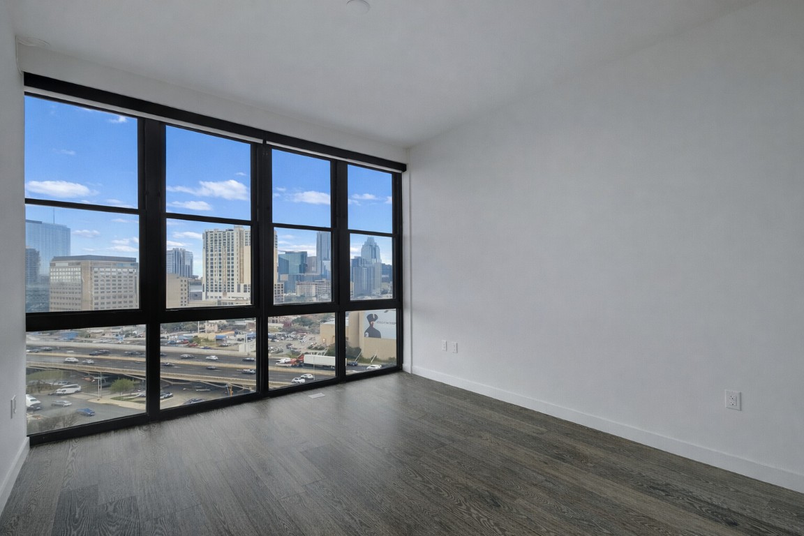 800 Embassy Drive, Unit 606 Austin, TX 78702 - Photo 21 of 38 wooden floor in an empty room with a window