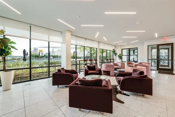 a living room with furniture large windows and flat screen tv