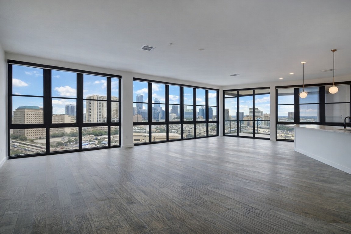 800 Embassy Drive, Unit 606 Austin, TX 78702 - Photo 4 of 38 a view of an empty room with wooden floor and a window