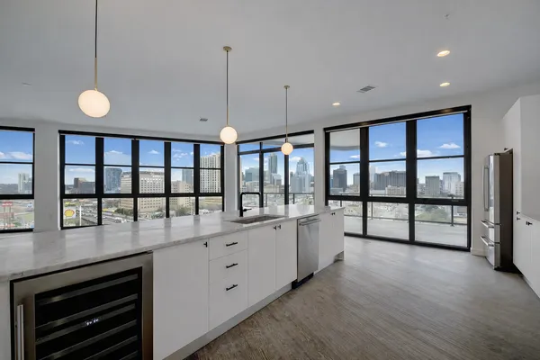 a open kitchen with stainless steel appliances granite countertop a stove and a large window