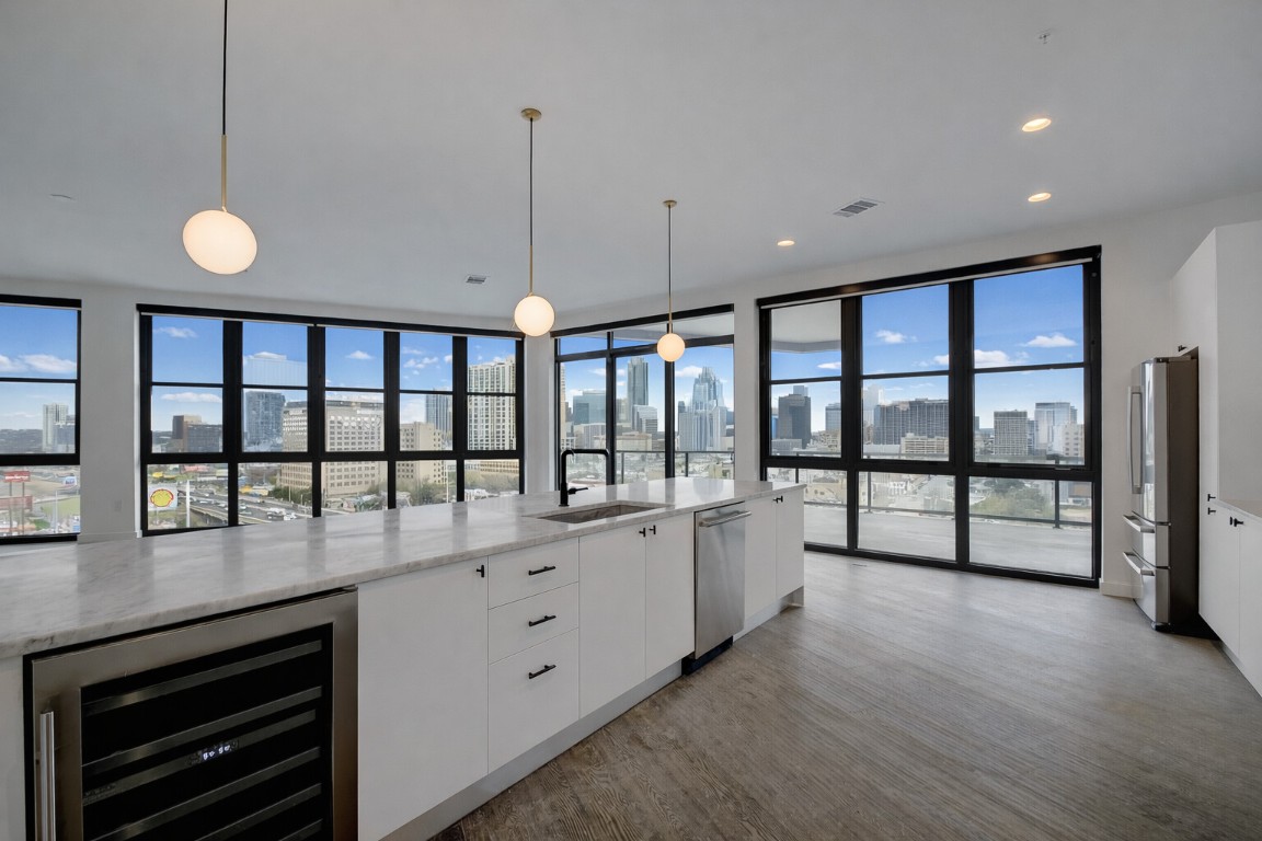 800 Embassy Drive, Unit 606 Austin, TX 78702 - Photo 8 of 38 a open kitchen with stainless steel appliances granite countertop a stove and a large window