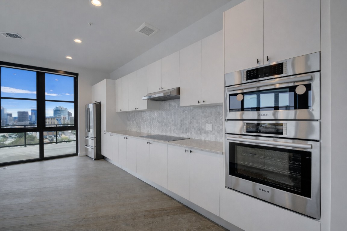 800 Embassy Drive, Unit 606 Austin, TX 78702 - Photo 10 of 38 a kitchen with stainless steel appliances granite countertop a stove and a microwave