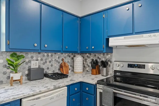 a kitchen with stainless steel appliances granite countertop a stove a microwave a sink and cabinets