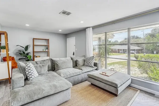 a living room with furniture and large windows