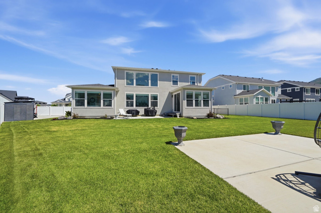 1165 West Union Bench Drive Mapleton, UT 84664 - Photo 54 of 61 Expansive rear yard featuring a large concrete patio, manicured lawn, and a light-colored stucco exterior with multiple windows