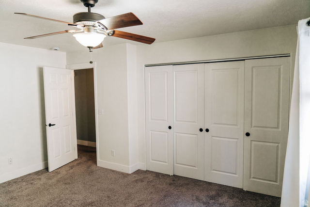 1825 West Mathis Park Place, Unit 40 St. George, UT 84770 - Photo 15 of 28 Unfurnished bedroom with dark carpet, a ceiling fan, and a closet