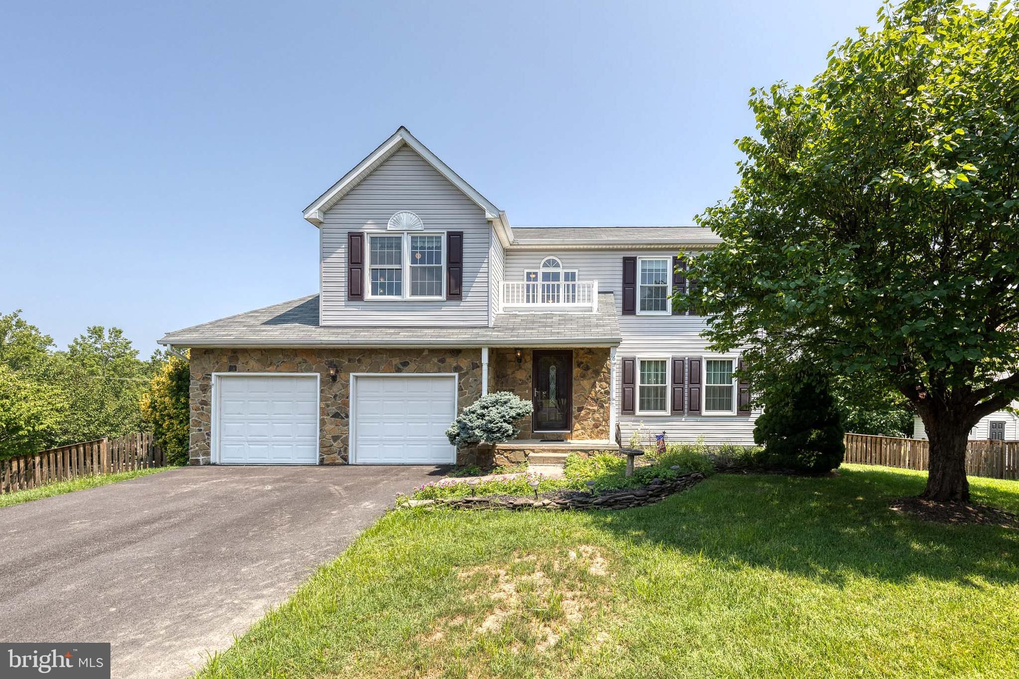 a front view of a house with a yard and trees