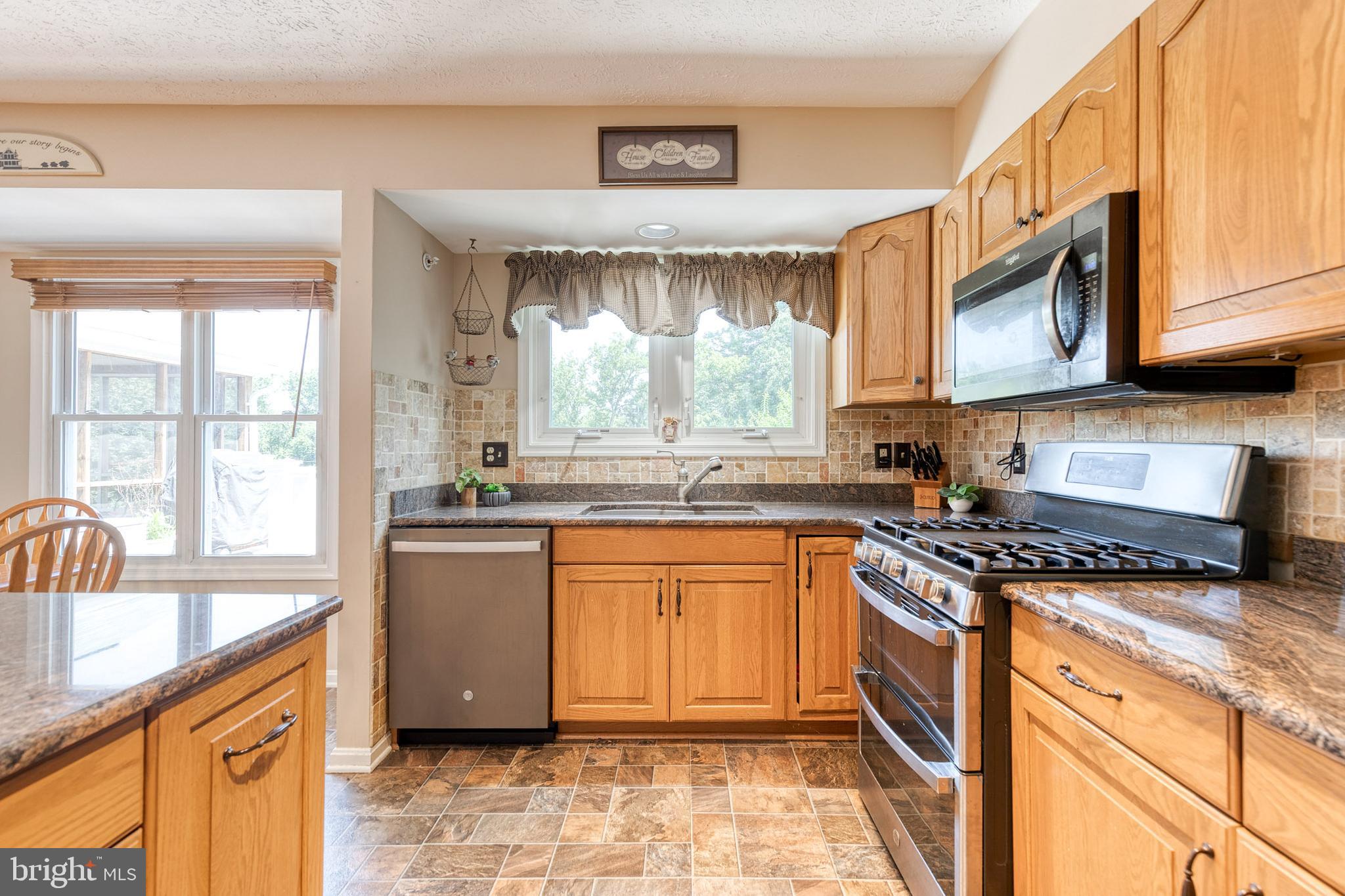 16 Perry Ridge Court Baltimore, MD 21237 - Photo 11 of 45 a kitchen with stainless steel appliances granite countertop a stove a sink and a microwave