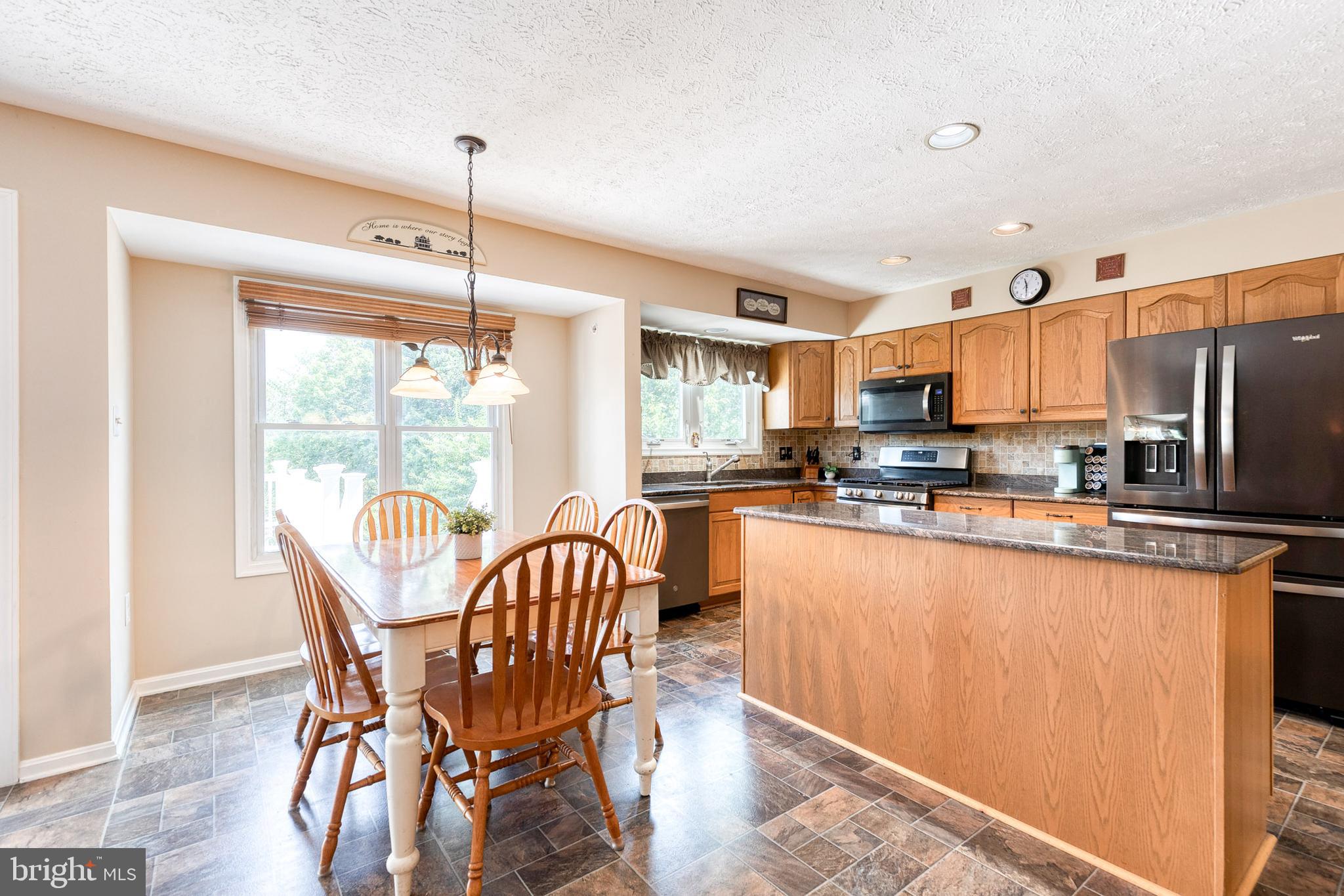 16 Perry Ridge Court Baltimore, MD 21237 - Photo 15 of 45 a kitchen with stainless steel appliances granite countertop a table chairs refrigerator and microwave