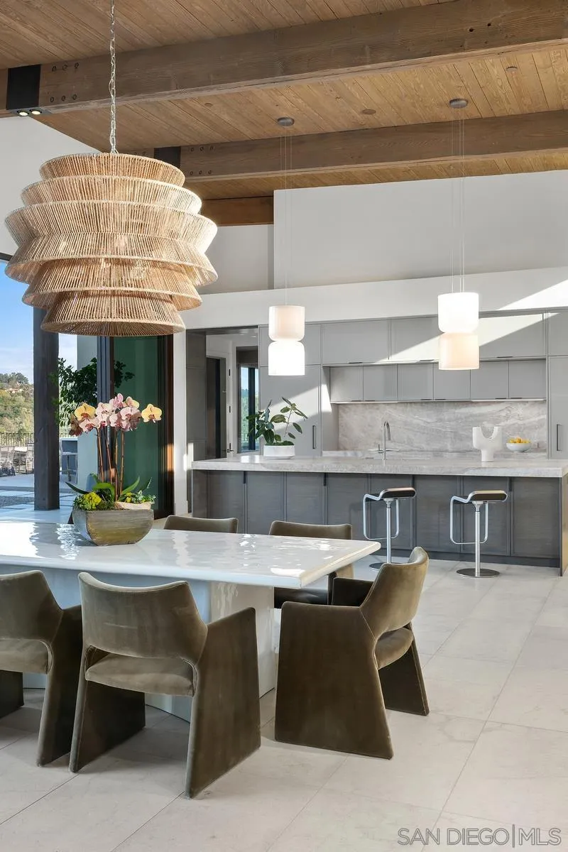 4728 El Aspecto Rancho Santa Fe, CA 92067 - Photo 12 of 34 a kitchen with stainless steel appliances kitchen island granite countertop a table chairs in it and wooden floor