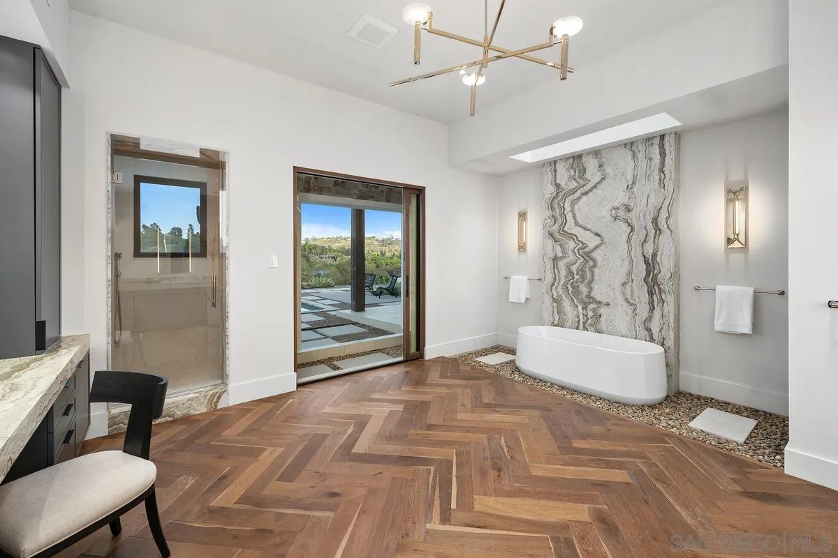 4728 El Aspecto Rancho Santa Fe, CA 92067 - Photo 20 of 34 a spacious bedroom with a large bed and a chandelier