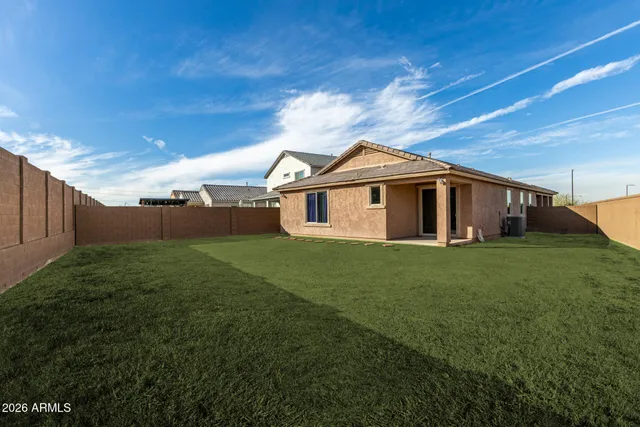 a view of a yard in front of a house with plants and large tree