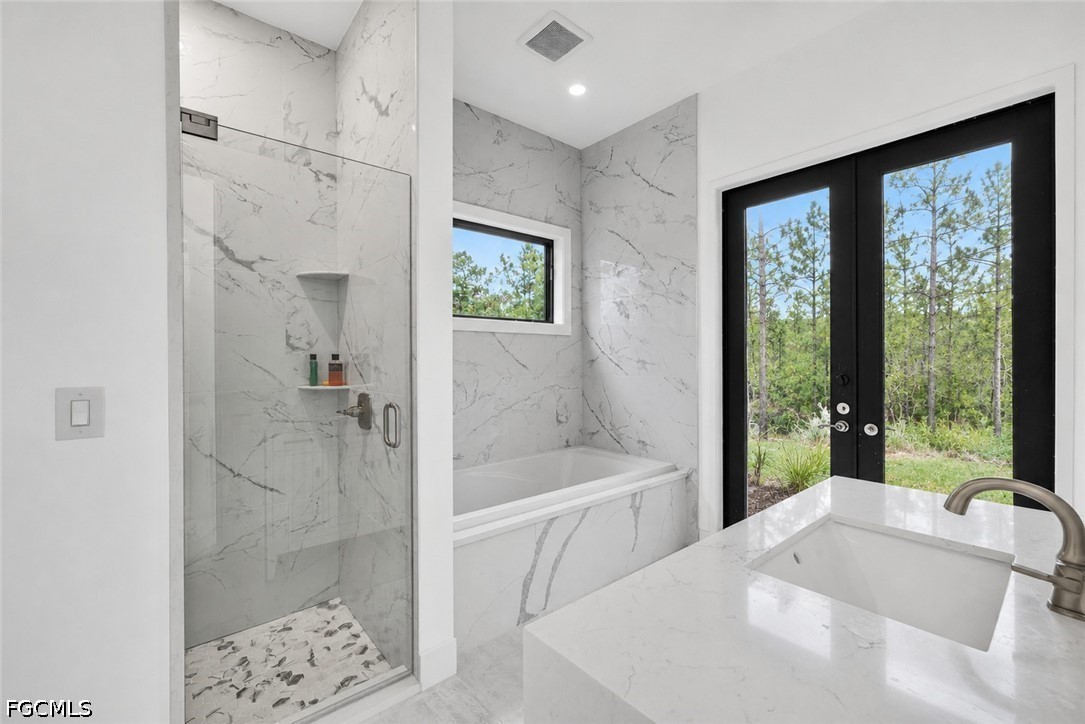 2665 Oil Well Road Naples, FL 34120 - Photo 18 of 40 a bathroom with a tub a sink and shower