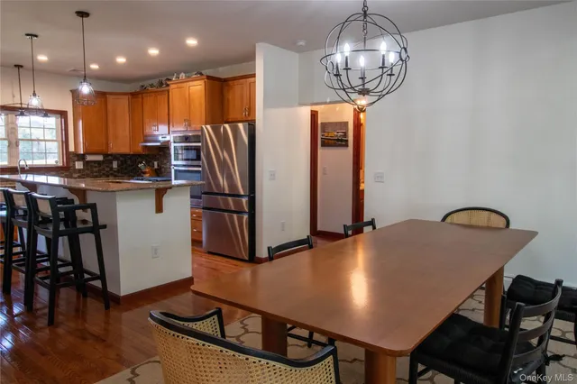 a kitchen with stainless steel appliances granite countertop a stove refrigerator a sink dishwasher with a dining table and chairs