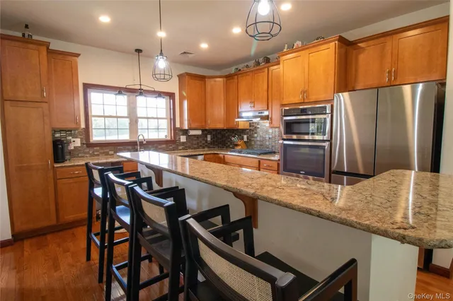 a kitchen with granite countertop a table chairs microwave and refrigerator
