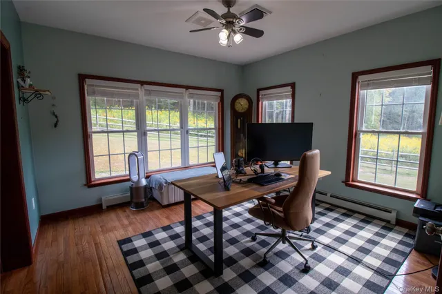 a view of a workspace with furniture and a window