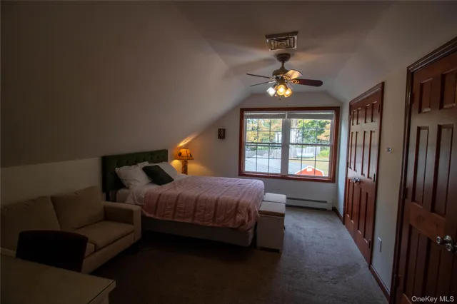 a bedroom with a bed and a flat tv screen on dresser