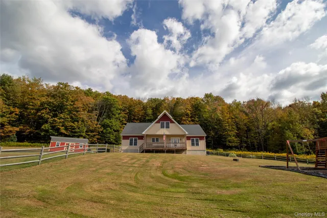 a view of a swimming pool with a yard and trees in the background