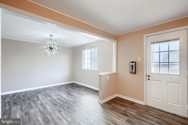 an empty room with windows and ceiling fan