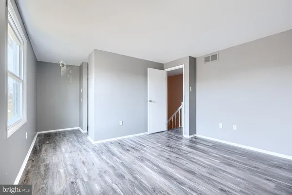 a view of room with window and wooden floor