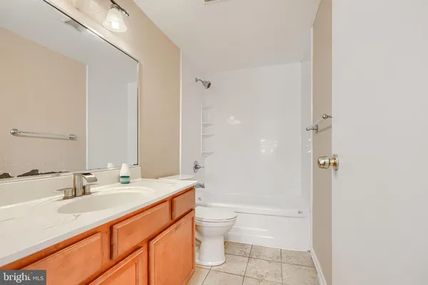 a bathroom with a granite countertop sink a toilet and shower